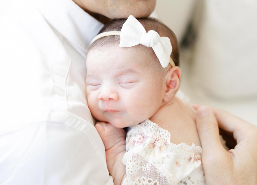 A newborn snuggling her papa during a newborn photography session in Northern Virginia