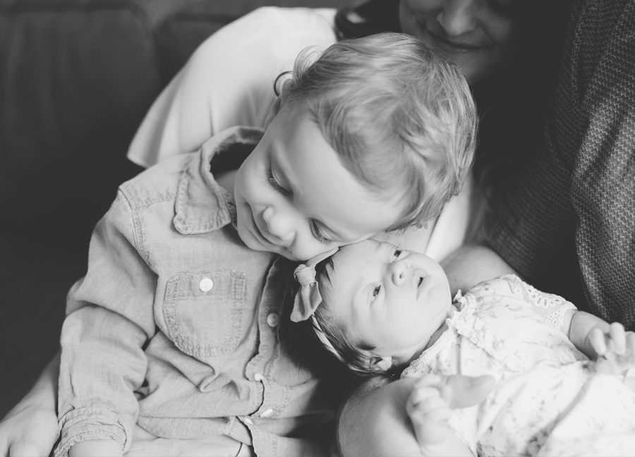 big brother and newborn baby sister snuggling captured by a newborn photographer in Washington DC