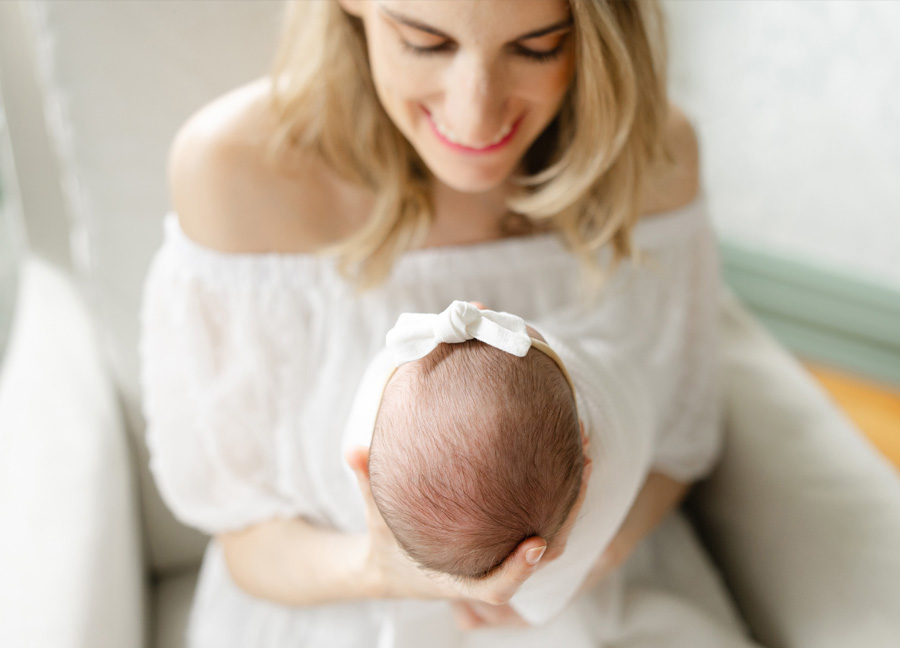 DIY newborn photos featuring a mom looking at her newborn and smiling