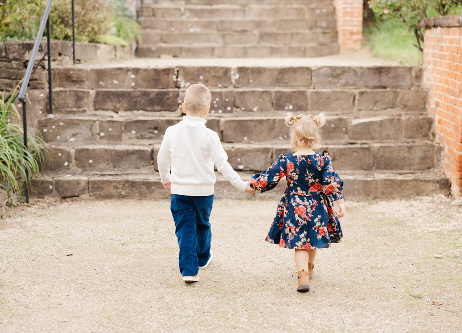 little boy and girl holding hands and walking