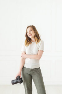 Stephanie Honikel newborn and family photographer in Leesburg Virginia standing with Camera.