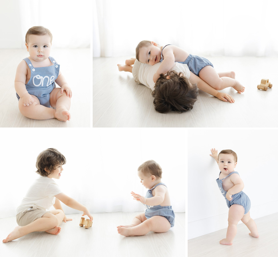 Baby boy celebrates his first birthday in a bright Northern Virginia studio, wearing a blue “One” romper during his milestone photography session. The collage captures individual portraits along with playful moments with his older brother, including cuddling, playing together, and baby standing independently.