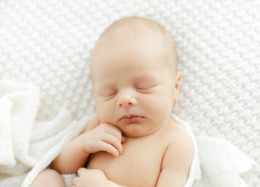 Newborn baby sleeping on a white blanket – Leesburg VA newborn photographer
